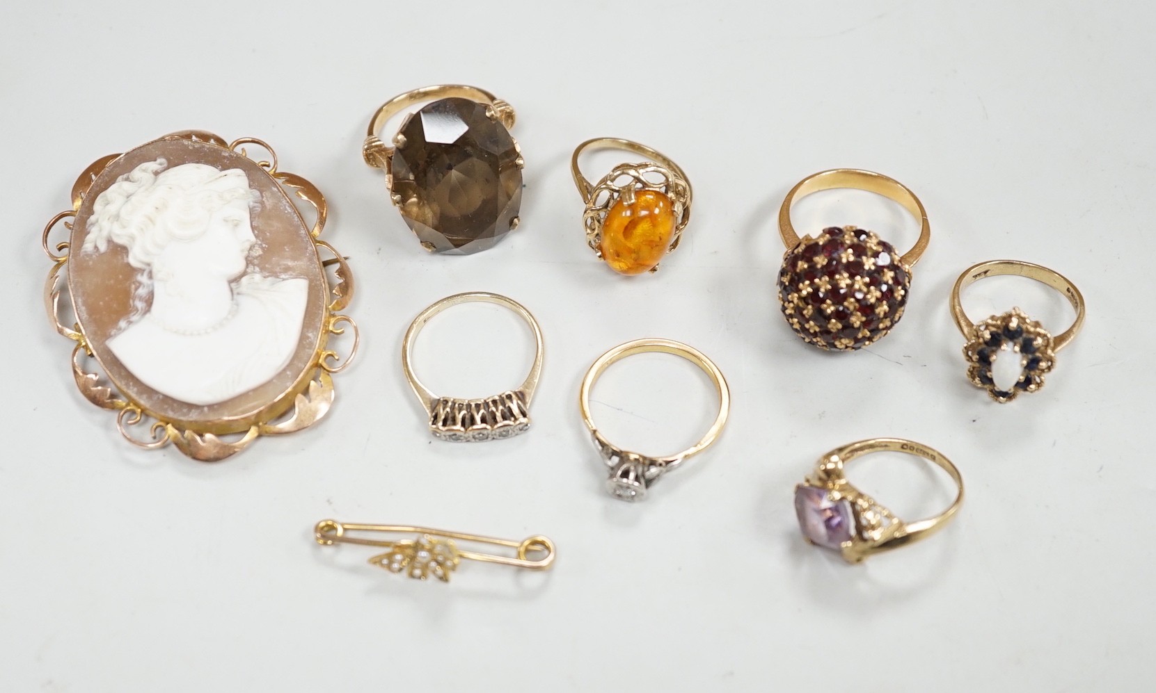 Two yellow metal and illusion set diamond rings, two 9ct gold and gem set rings, two yellow metal and gem set rings and two brooches, including 9ct mounted cameo shell.